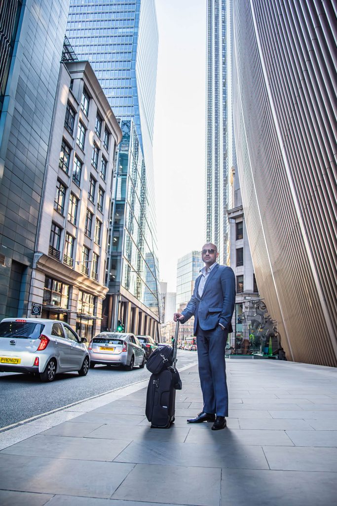 Urbanes Business Portrait eines Mannes mit Koffer – Businessreise in Köln