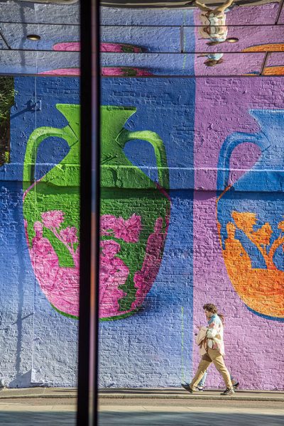 Farbintensive Wandmalerei mit Vasenmotiv und Passant – Streetart in London