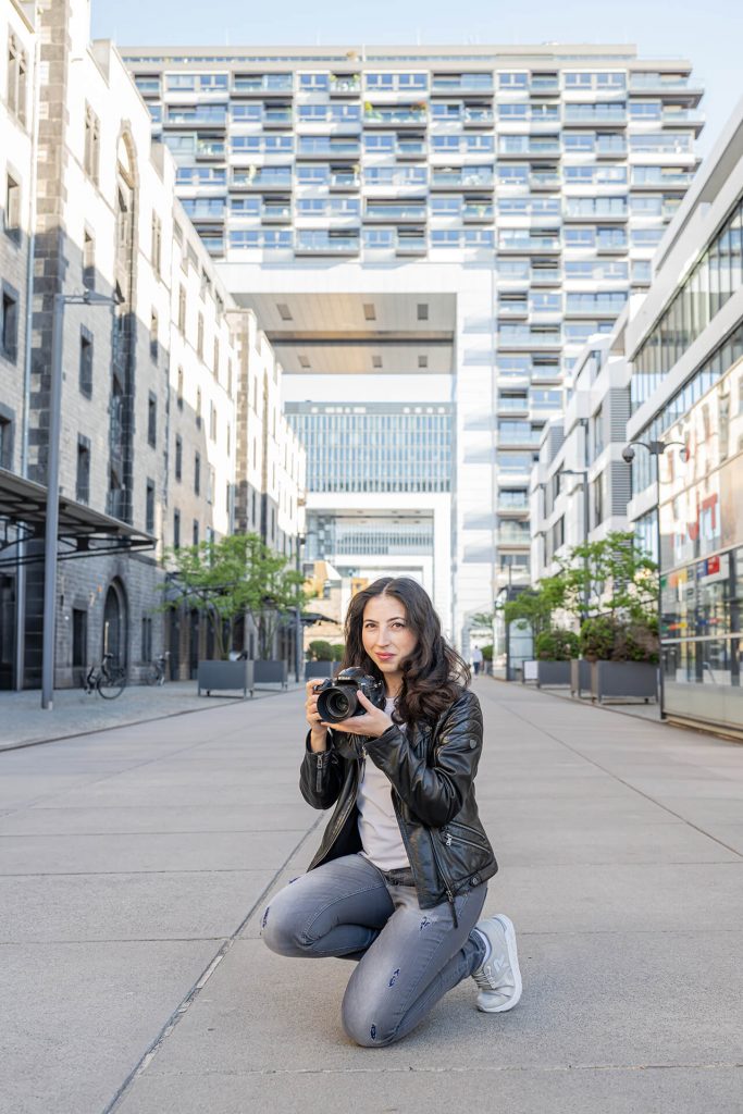 Fotografin in Köln: Julia Tschirka mit Kamera in den Kranhäusern – modernes Businessportrait für Website und Social Media