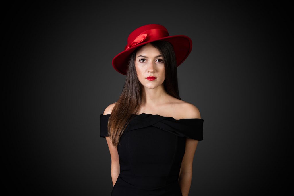 Porträtshooting Köln – Stilvolles Damenporträt mit rotem Hut, zeitlos elegant