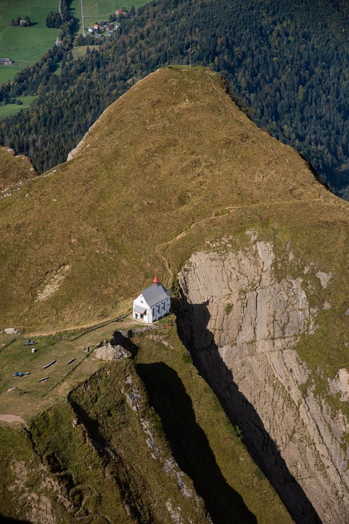Kirche am See mit Panoramablick auf schneebedeckte Berge