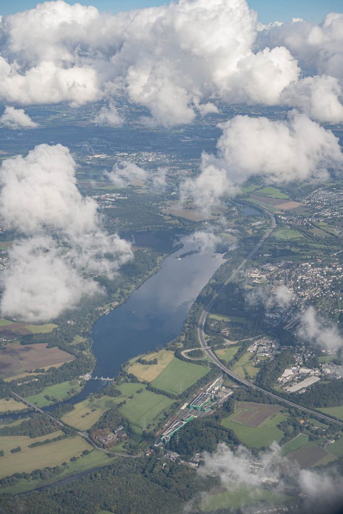 Flusslandschaft mit Feldern und Wolken aus der Vogelperspektive