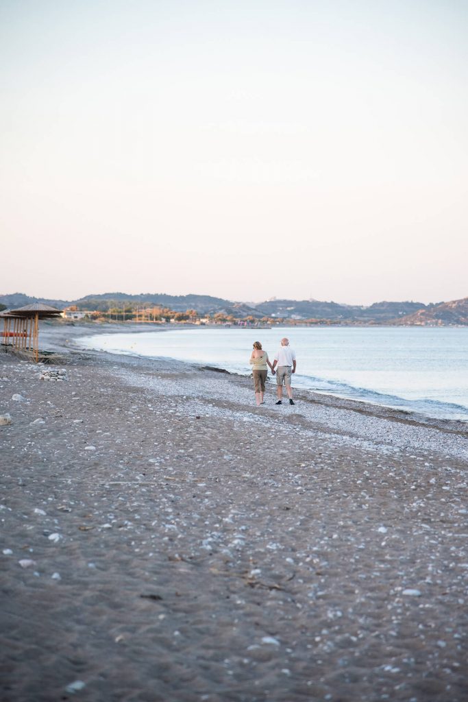 Ein älteres Paar spaziert entlang der Küste am Meer