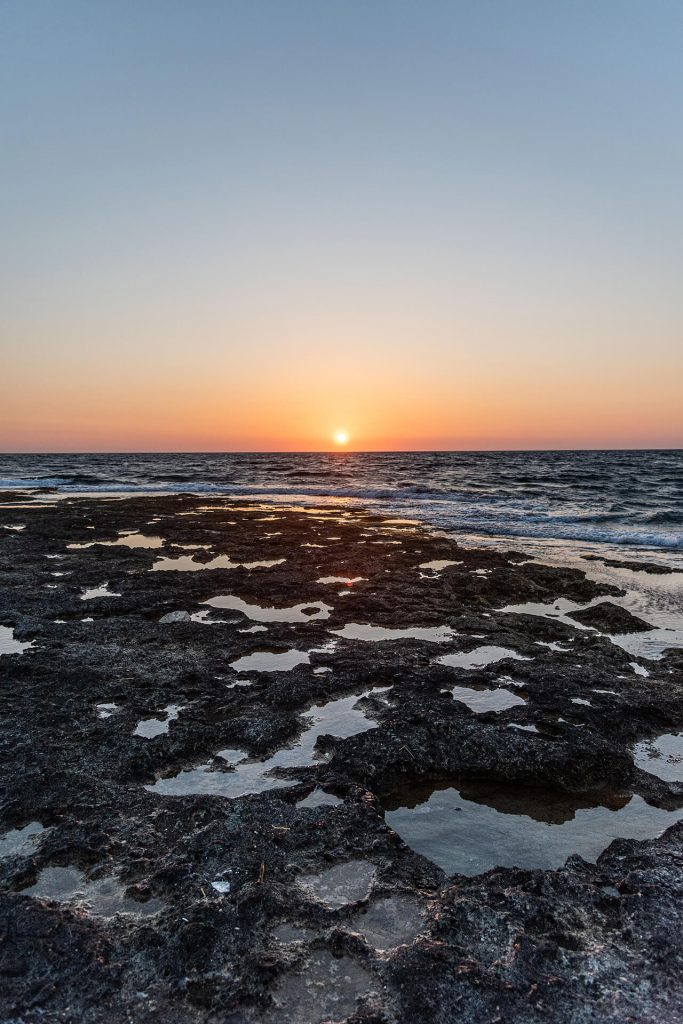 Sonnenuntergang über der Felsenküste mit Wasserpfützen – Zypern