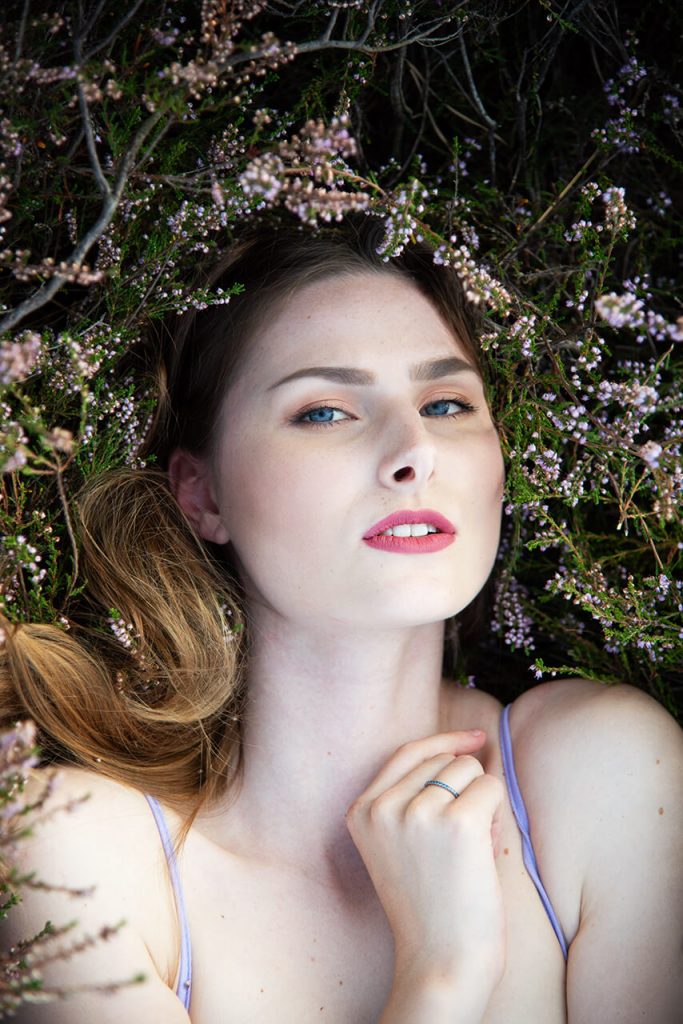 Märchenhaftes Shooting Köln – Frau in blauem Spitzenoberteil liegt im Lavendel und schaut zur Seite