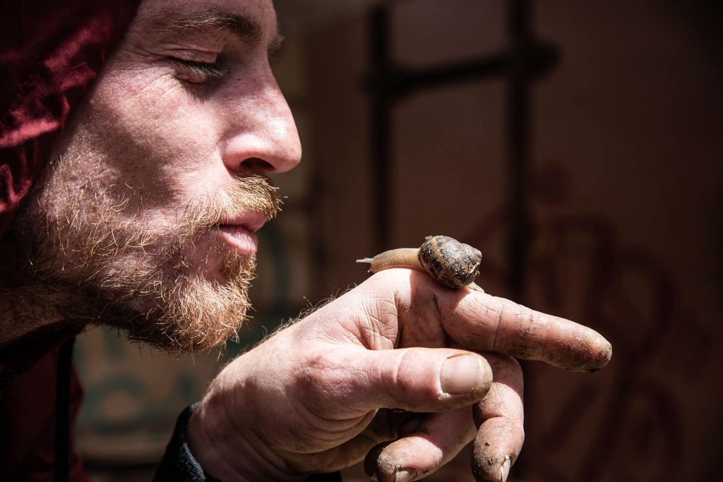 Mann mit Schnecke auf dem Finger – intensives Porträt mit Street-Charakter