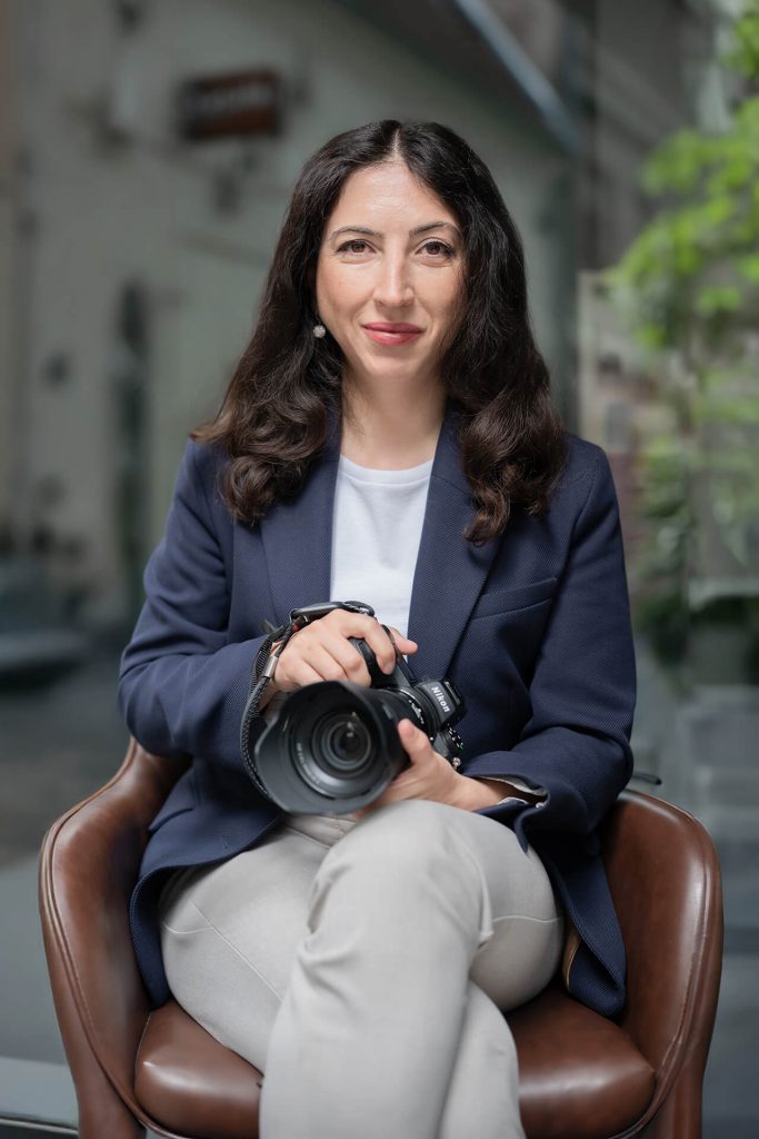 Business Portrait von Dr. Julia Tschirka – professionelle Fotografin in Köln, mit Kamera in der Hand, im modernen urbanen Ambiente.