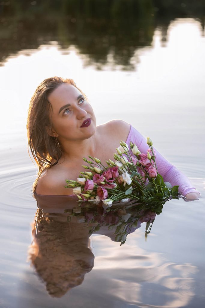 Frau mit Blumen im Wasser, der Blick schweift träumerisch in die Ferne