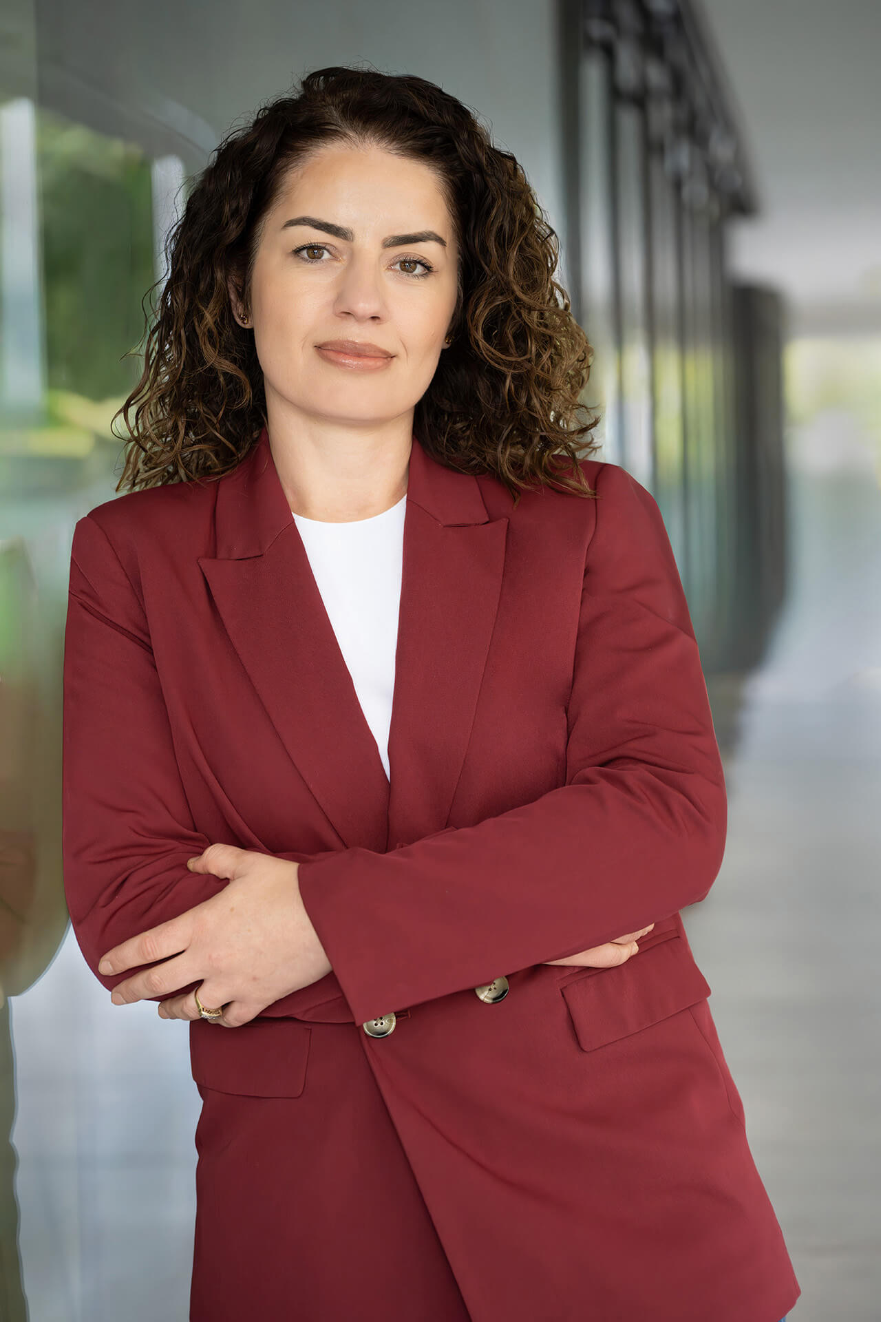 Professionelles Bewerbungsfoto einer Frau im Business-Outfit mit seriösem Blick in modernem Büroambiente.