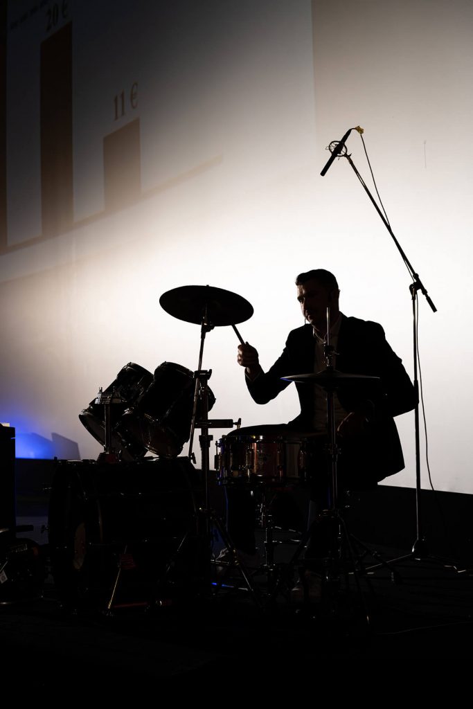 Drummer als Silhouette auf der Bühne bei TEDxEssen, Prof. Dr. Samuel Stäbler mit der Rede Inspiring Human Generosity: Academic Insights from Street Music