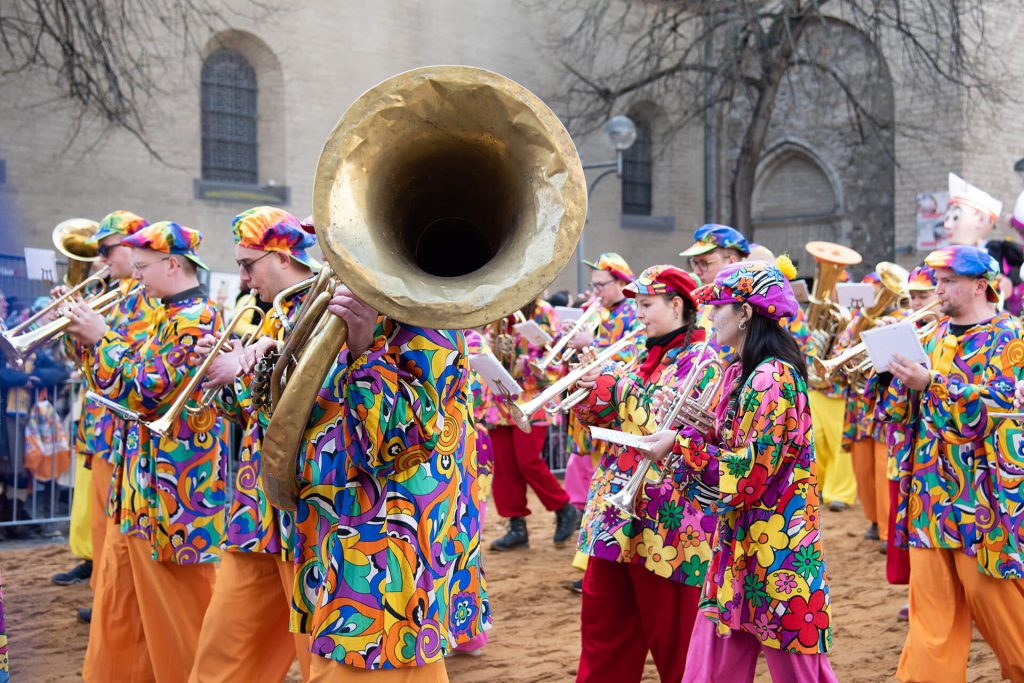 Bunte Marching Band mit Blasinstrumenten spielt beim Karneval in Köln.