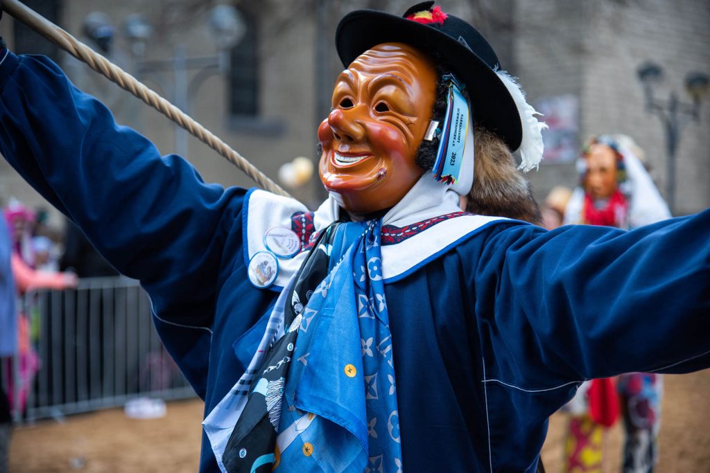 Maskierter Performer in blauem Kostüm beim Kölner Karneval in Nahaufnahme.