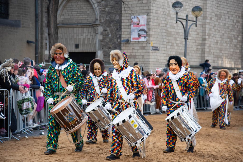 Trommlergruppe in bunten Kostümen spielt im Kölner Karnevalsumzug.