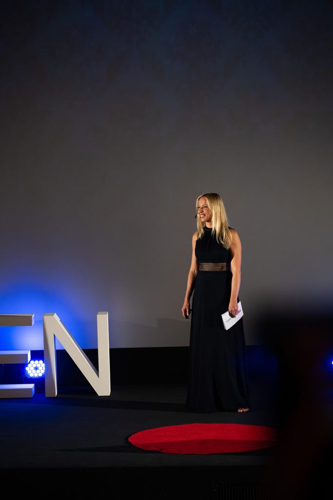 Moderatorin Dr. Viktoriya Sokolova auf der Bühne bei TEDxEssen, im eleganten Abendkleid