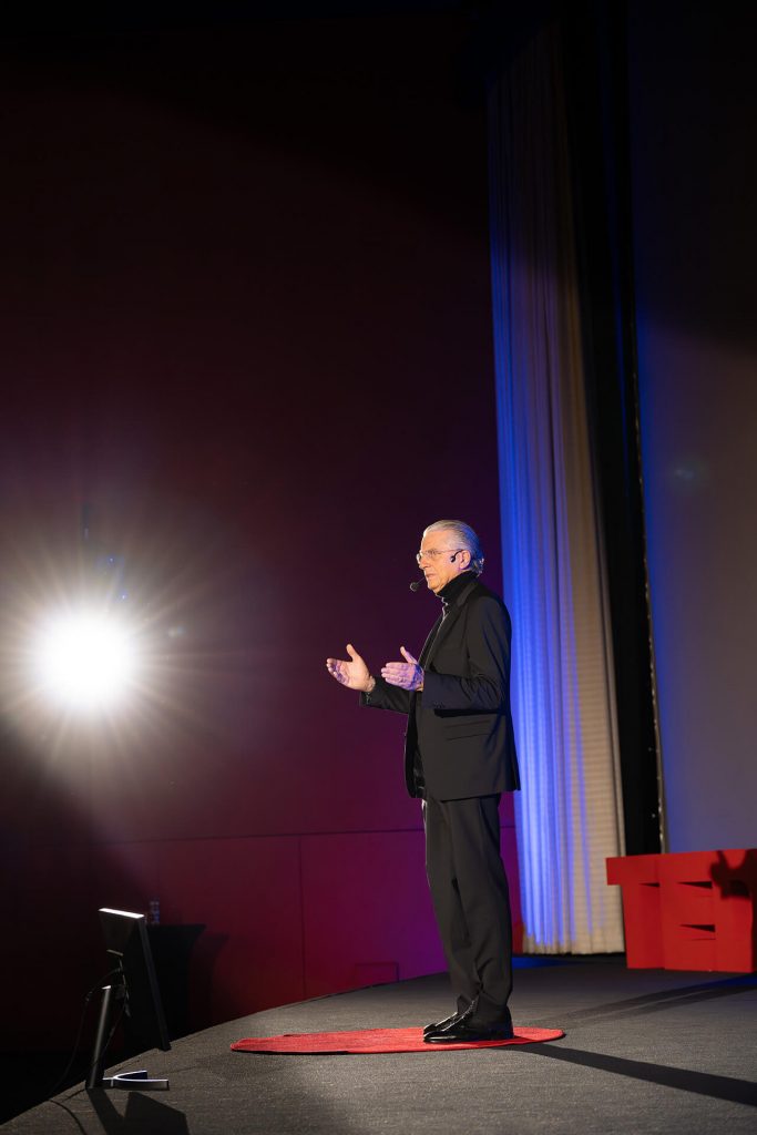 Speaker mit Headset auf der Bühne, angestrahlt, bei TEDxEssen, Prof. Dr. Jochen A. Werner mit der Rede: Zwischen Algorithmus und Atemzug