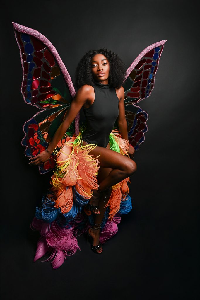 Fine-Art-Fantasy-Editorial-Porträt einer Frau in schwarz mit farbigen Schmetterlingsflügeln