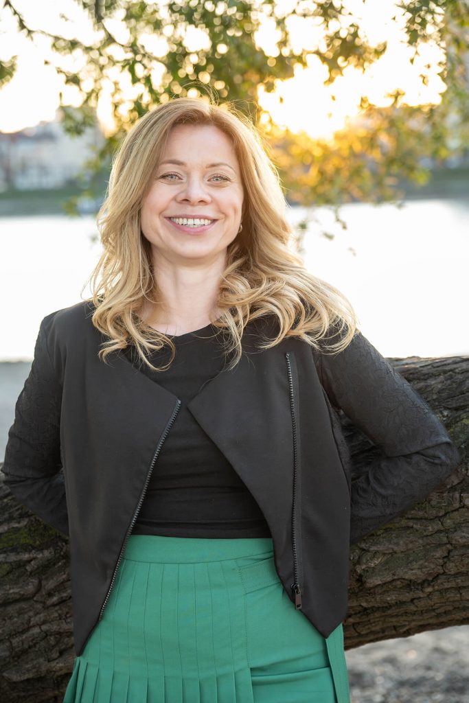 Lächelnde Frau am Rhein bei einem natürlichen Outdoor-Portrait in Köln