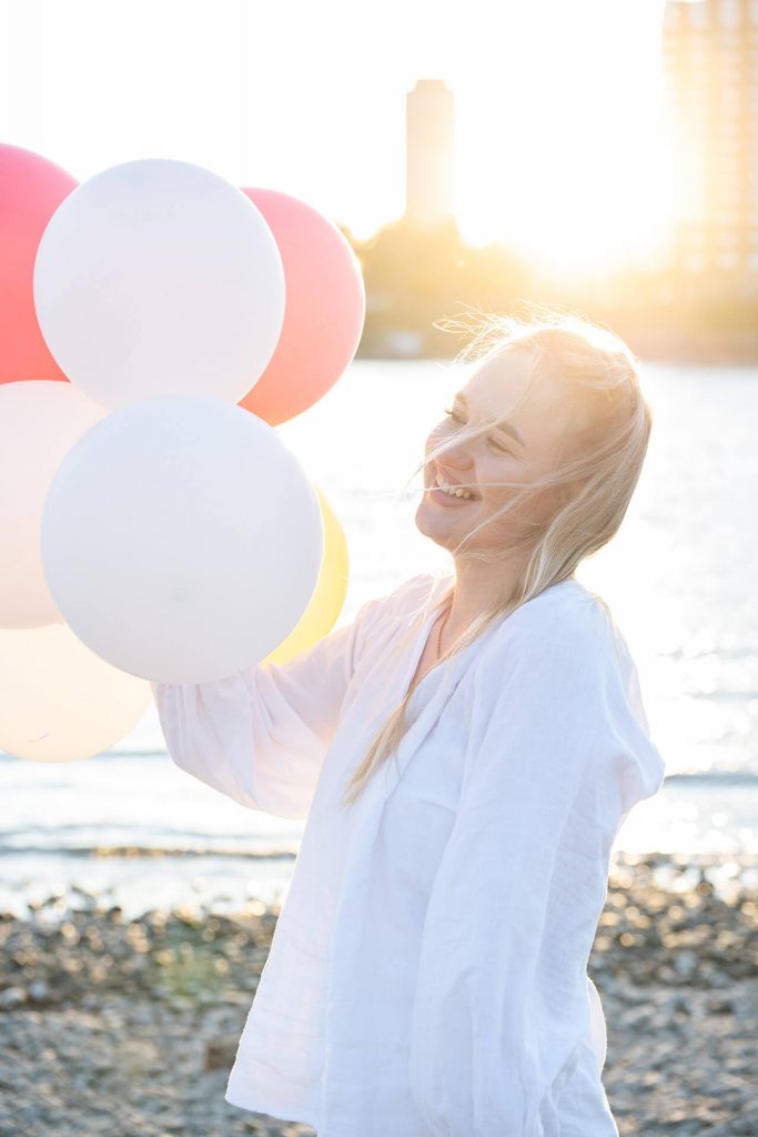 Lächelnde Frau am Rhein bei einem natürlichen Outdoor-Portrait in Köln